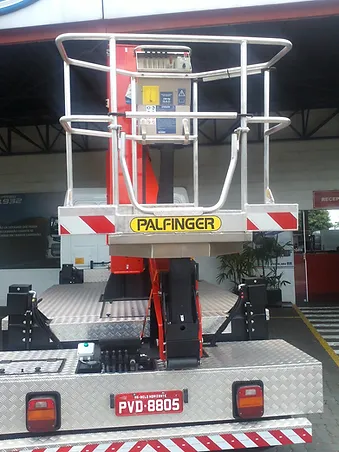 Caminhão Madal Palfinger P240A da ATW Brasil com a plataforma aérea estendida em um ambiente de trabalho.