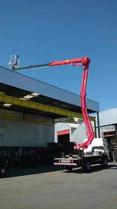 Caminhão Madal Palfinger P240A da ATW Brasil com a plataforma aérea estendida em um ambiente de trabalho.